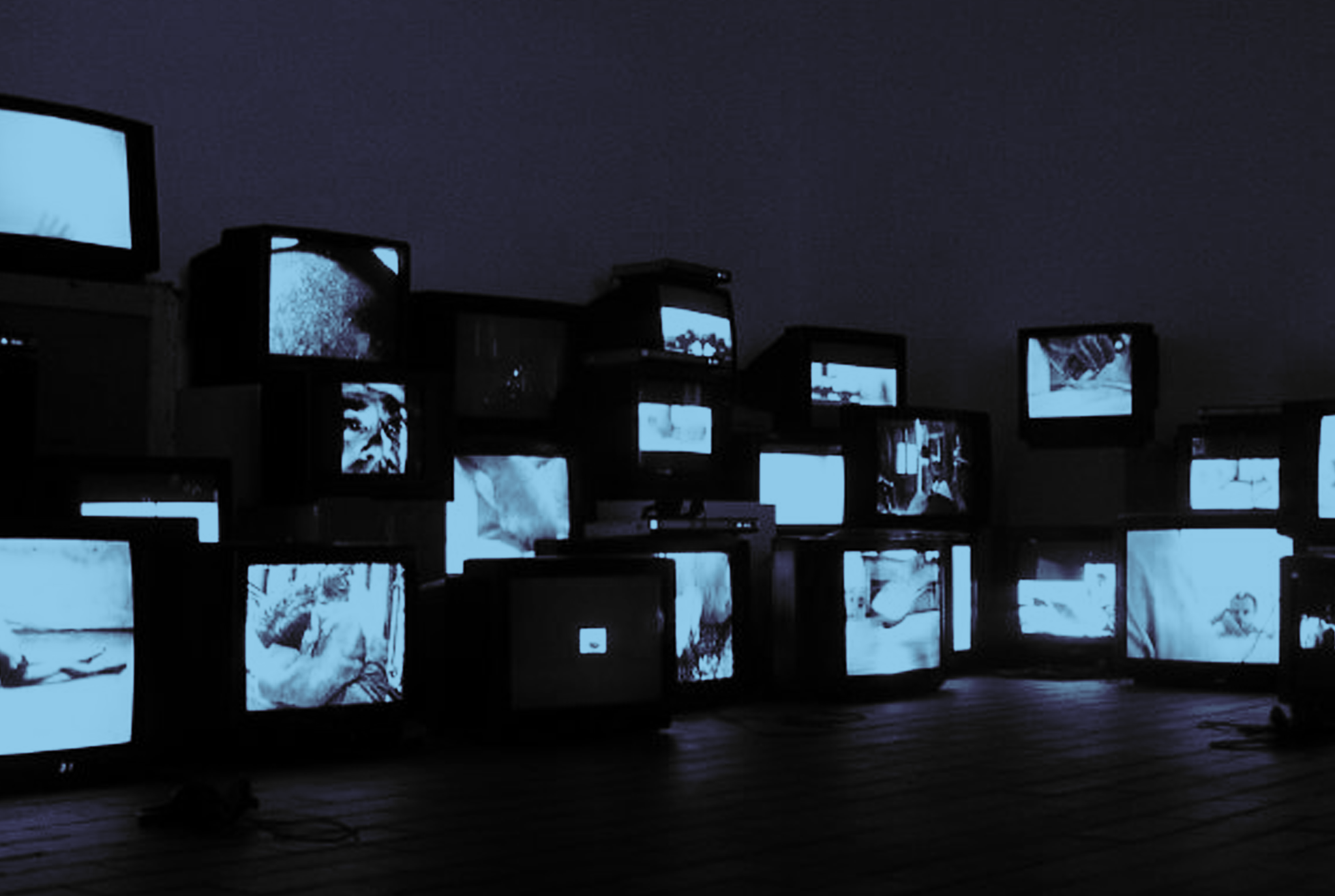 A collection of televisions screens in a dark room